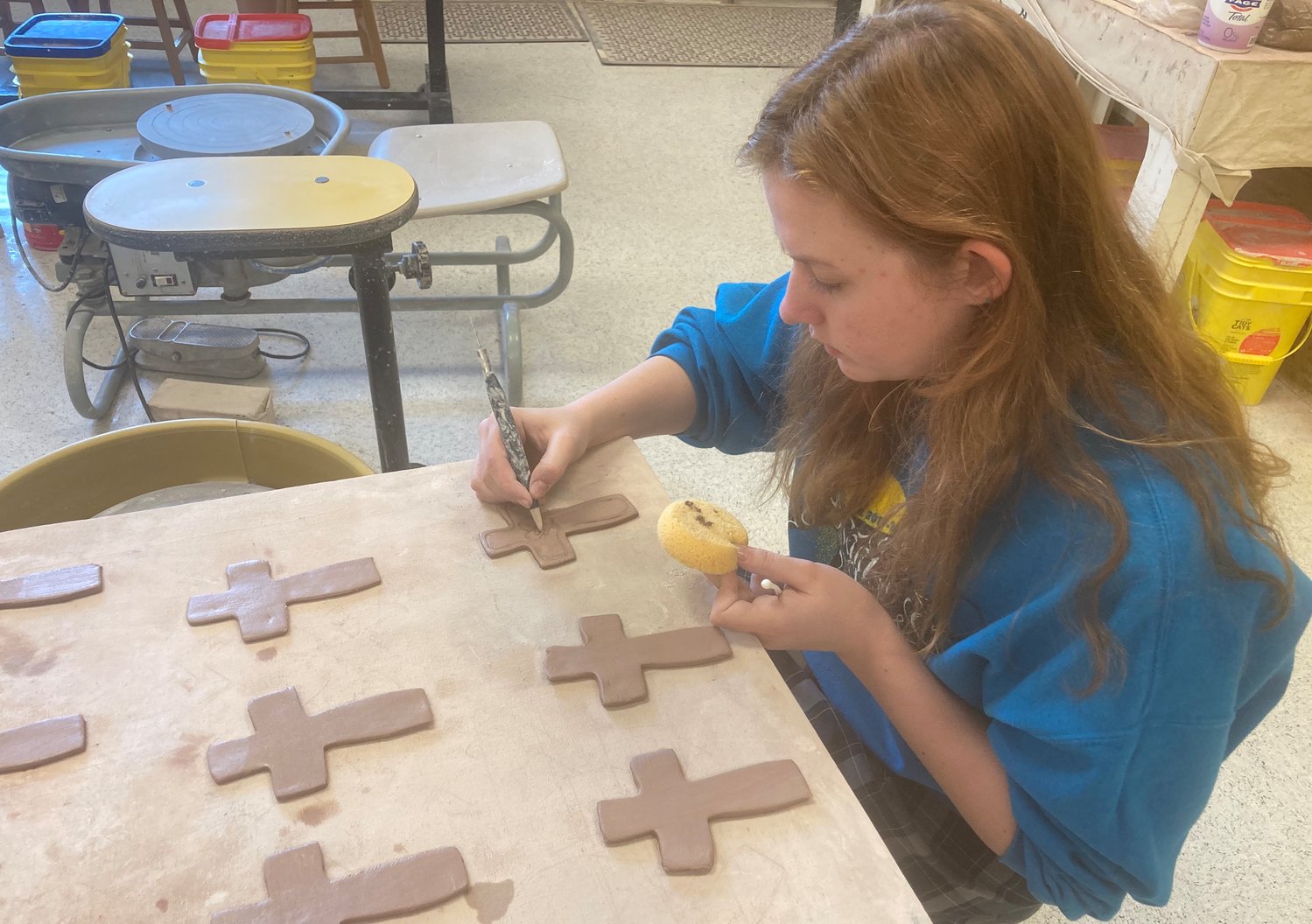 St. Joseph Catholic School art student Elizabeth Coleman creates crosses from clay. The crosses will eventually turn into student-created ceramic art.